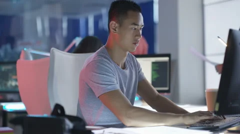 4K Computer game designer working at his desk &amp; looking into VR viewer Stock Footage 67903572