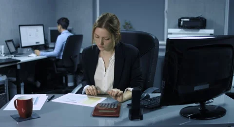 4K: At a computer workstation a young female employee calculates the correctness Stock Footage 67465043