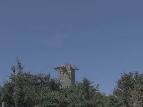 4k concrete bunker behind trees in front of clear blue sky Video stock 75158841