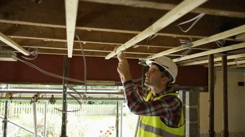 4K Construction worker on a building site checking roof struts &amp; wiring Stock Footage 65117438