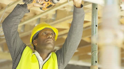 4K Construction worker on a building site checking roof struts & wiring Stock Footage