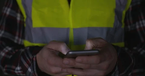 4k Construction worker wearing hi vis texting on phone in yellow hi-vis vest Vídeos de archivo 89853225