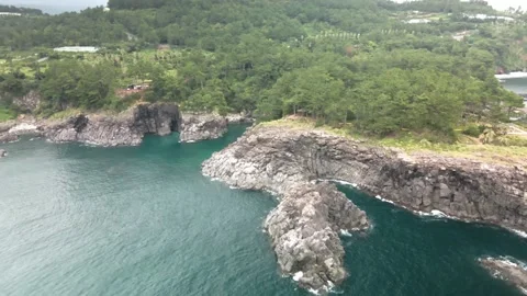 4K Counter-clockwise Drone Shot of a Hill East to Ohoedolgase (외돌개), Jeju Island Stock Footage 143863829