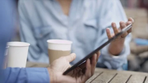 4K Couple Chatting &amp; Looking At Computer Tablet At Outdoor Cafe Table In City Stock Footage 75681361