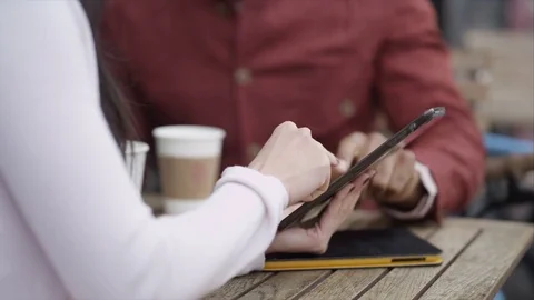 4K Couple Chatting &amp; Looking At Computer Tablet At Outdoor Cafe Table In City Stock Footage 75682505