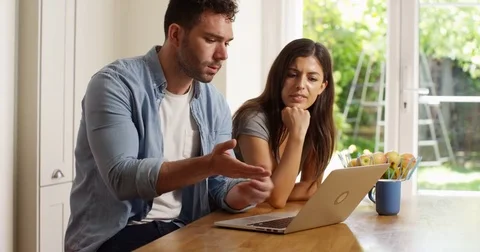 4K Couple together at home, looking at laptop, trying to solve a problem Video stock 80100265