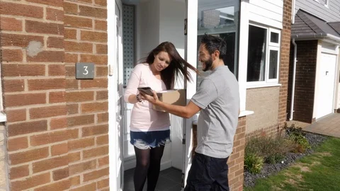 4K: Courier delivers a Package / parcel to a house or front door of home. Stock Footage 123301391