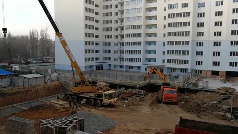 4K Crane Is Working &amp; Excavator Is Digging and Loading Ground To A Dump Truck Stock Footage 83721570