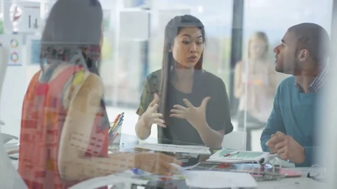 4K Creative business team looking at photos &amp; printed graphs in a meeting Stock Footage 76032923