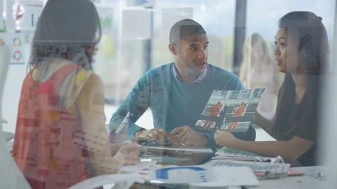 4K Creative business team looking at photos &amp; printed graphs in a meeting Stock Footage 76032980