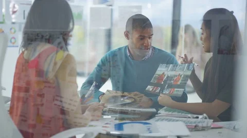 4K Creative business team looking at photos &amp; printed graphs in a meeting Stock Footage 76033013