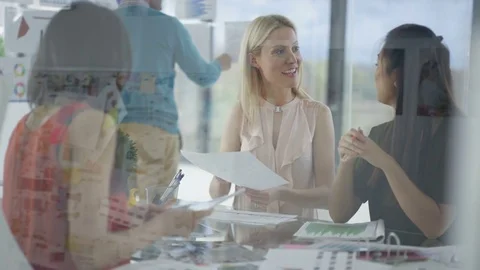 4K Creative business team looking at photos &amp; printed graphs in a meeting Stock Footage 76033089