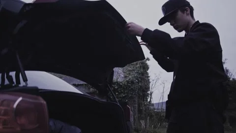 4k Crime Shot of Detective looking at Victim in the Car Boot Stock Footage 321865614