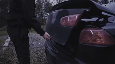 4k Crime Shot of Detective looking at Victim in the Car Boot Stock Footage 321865616