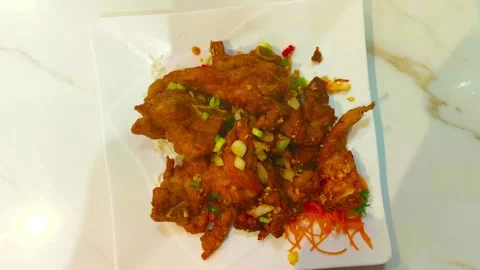 4K crispy spicy deep fried pork chop food garnished with vegetables peppers.. Video stock 318132055