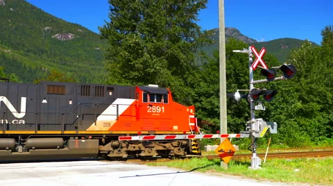 4K Crossing Barrier and Train Passing Behind, Large Red Diesel Locomotive Engine Stock Footage 68786345