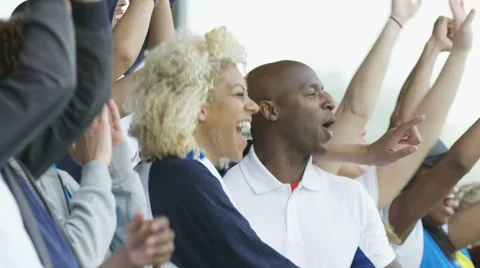4K Crowd of spectators cheering at sports event, woman holding British flag Stock Footage