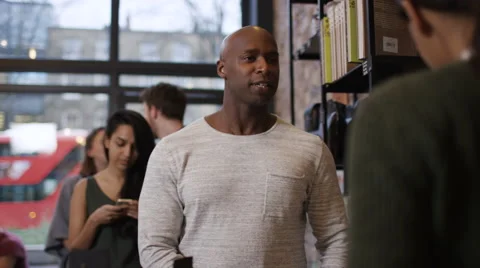 4K Customer in cafe makes payment with smartphone while queue of customers wait  Stock Footage 61873078