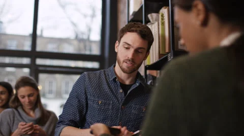 4K Customer in cafe makes payment with credit card while queue of customers wait 스톡 동영상 61873825