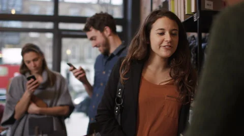 4K Customer in cafe makes payment with smartphone while queue of customers wait  Stock Footage