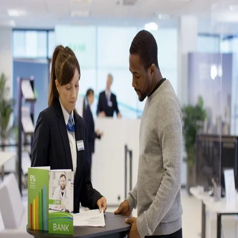 4K Customer waits to meet with financial adviser in modern bank Stock Footage