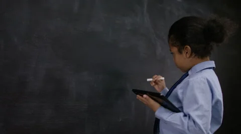 4K Cute little boy with tablet computer writing math sum on blackboard Stock Footage 59706874