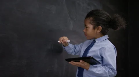 4K Cute little boy with tablet computer writing math sum on blackboard Stock Footage 59707039