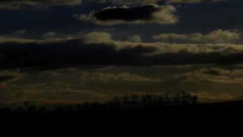 4K Dark Sky Timelapse: Moody Clouds Drifting Left Over Rising Tree Silhouettes Stock Footage 325194429
