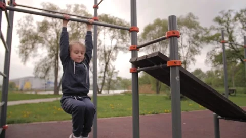 4K Daughter doing ABS exercises on open air sport playground Video stock 131156967