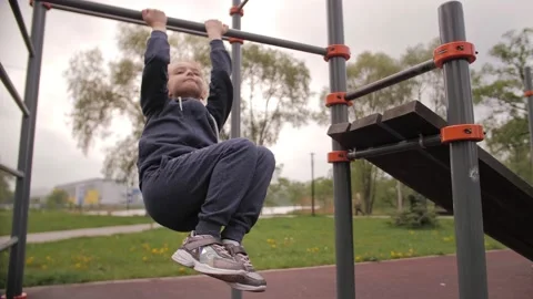 4K Daughter doing ABS exercises on open air sport playground Stock Footage 131893141