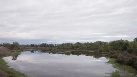 4K Day to Night Time Lapse of Clouds Over A Pond Stock Footage 69777421