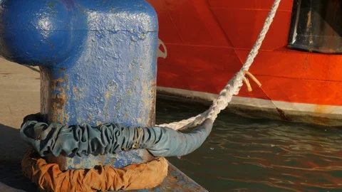 4k daylight close up static shot of a red ship moored to a blue bollard Stock Footage 123489393