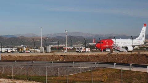 4k daylight static shot of a Norwegian airline passenger airplane on an airstrip Stock Footage 123773387