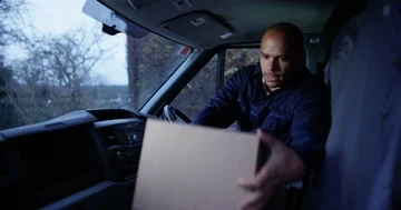 4K Delivery driver sitting in his vehicle checking off completed deliveries Stock Footage 85600744