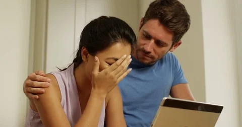 4K Depressed woman crying in front of computer &amp; her partner offering support Stock Footage 80469835