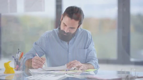 4K Designer working at his desk takes a break to turn &amp; look out of the window Stock Footage 76055517