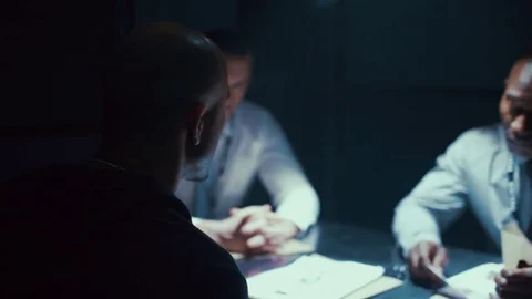 4K Detectives giving tough questioning to crime suspect at police station Stock Footage 73523926