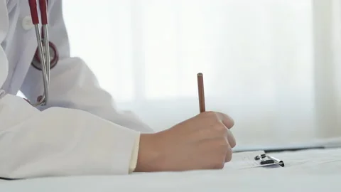 4K, The doctor is using a brown pencil to write down the patient's symptoms Stock Footage 170100598