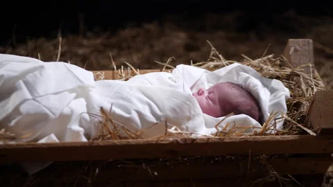 4K Dolly: Baby Jesus sleeping in a Manger with straw and Hay. Christmas Scene Stock Footage