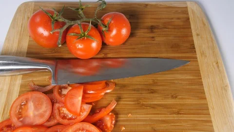 4k Dolly over top of sliced bright red tomatoes on the vine. food preperation Stock Footage 90160088