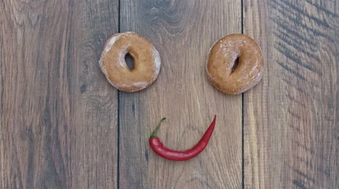 4k Donuts Composition on a Wooden Background with Chilli Face 스톡 동영상 65260679