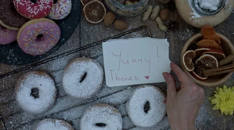 4k Donuts Composition on a Wooden Background with the note: Yummy, Thanks! Stock Footage 65261404