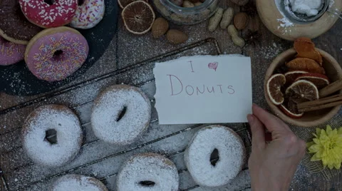 4k Donuts Composition on a Wooden Background with Paper: I love Donuts Stock Footage 65261433