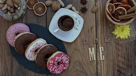 4k Donuts Composition on a Wooden Background with words Eat Me Stock Footage 65263878