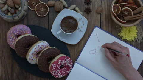 4k Donuts Composition on a Wooden Background with a hand writing I love donuts Stock-Footage 65264090