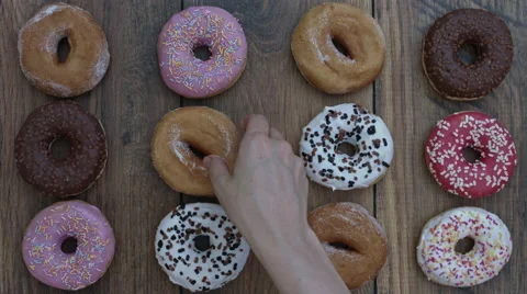 4k Donuts Composition on a Wooden Background with a Bite Stock Footage 65264334