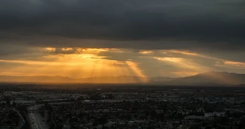4k - Dramatic sunrays through clouds over busy valley Stock Footage 89818252