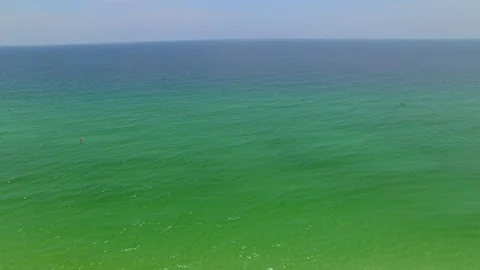 4K Drone Backing Up From Emerald Green Ocean Water Over Beach Stock Footage 109373268