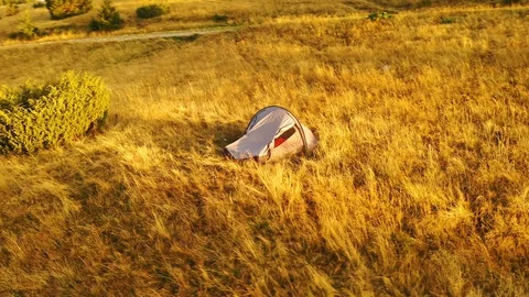 4k drone clip with two mountain bikes and a tent on a mountain meadow at sunrise 스톡 동영상 118082770