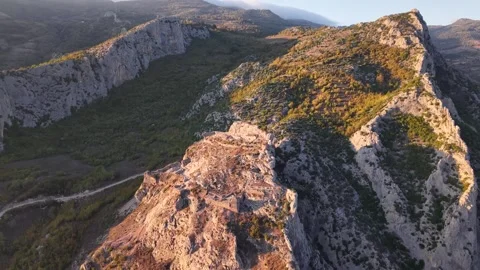 4K Drone Descent Toward Ancient Ruined Castle on Green Mountain at Sunset Stock-Footage 337243807